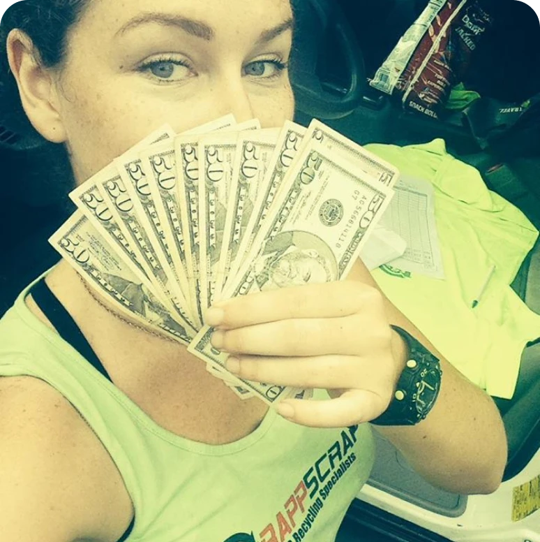 Individual showcasing money with a smile